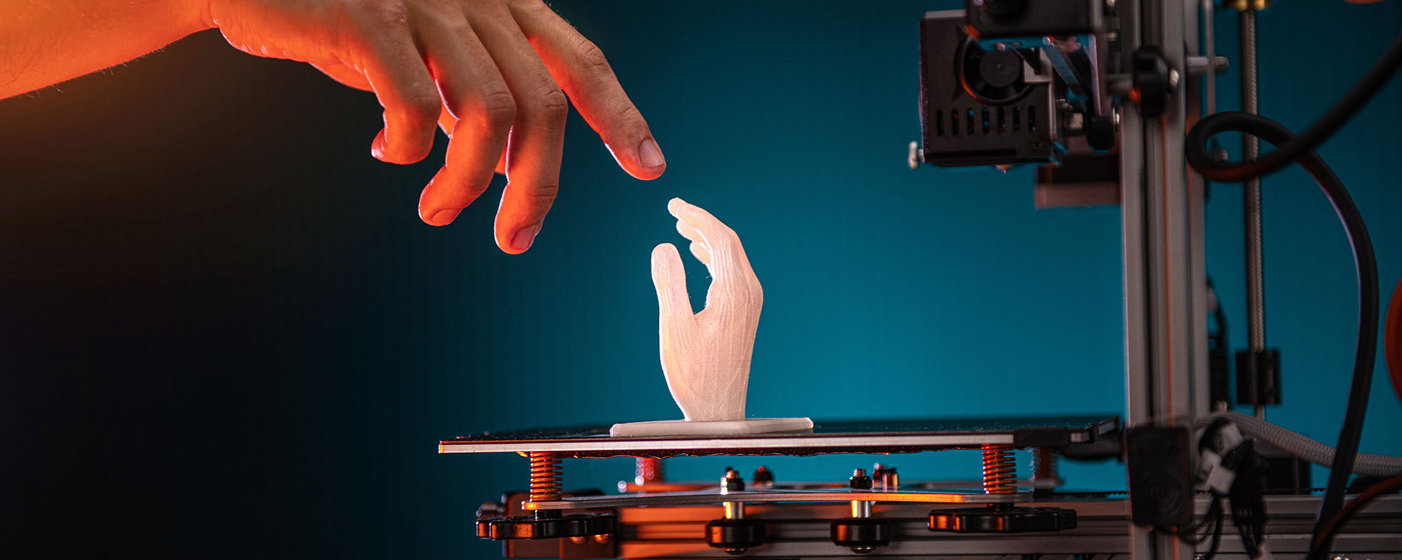 3D printing in progress. 3d printer printed a hand. A man touches the product printed on a 3d printer. God's touch, biblical motives. High quality photo